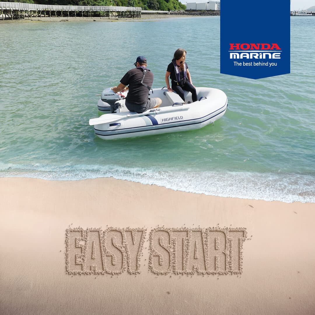 Two people ride a white inflatable boat near a sandy beach with a Honda outboard, while a blue Honda Marine banner appears in the top-right corner.