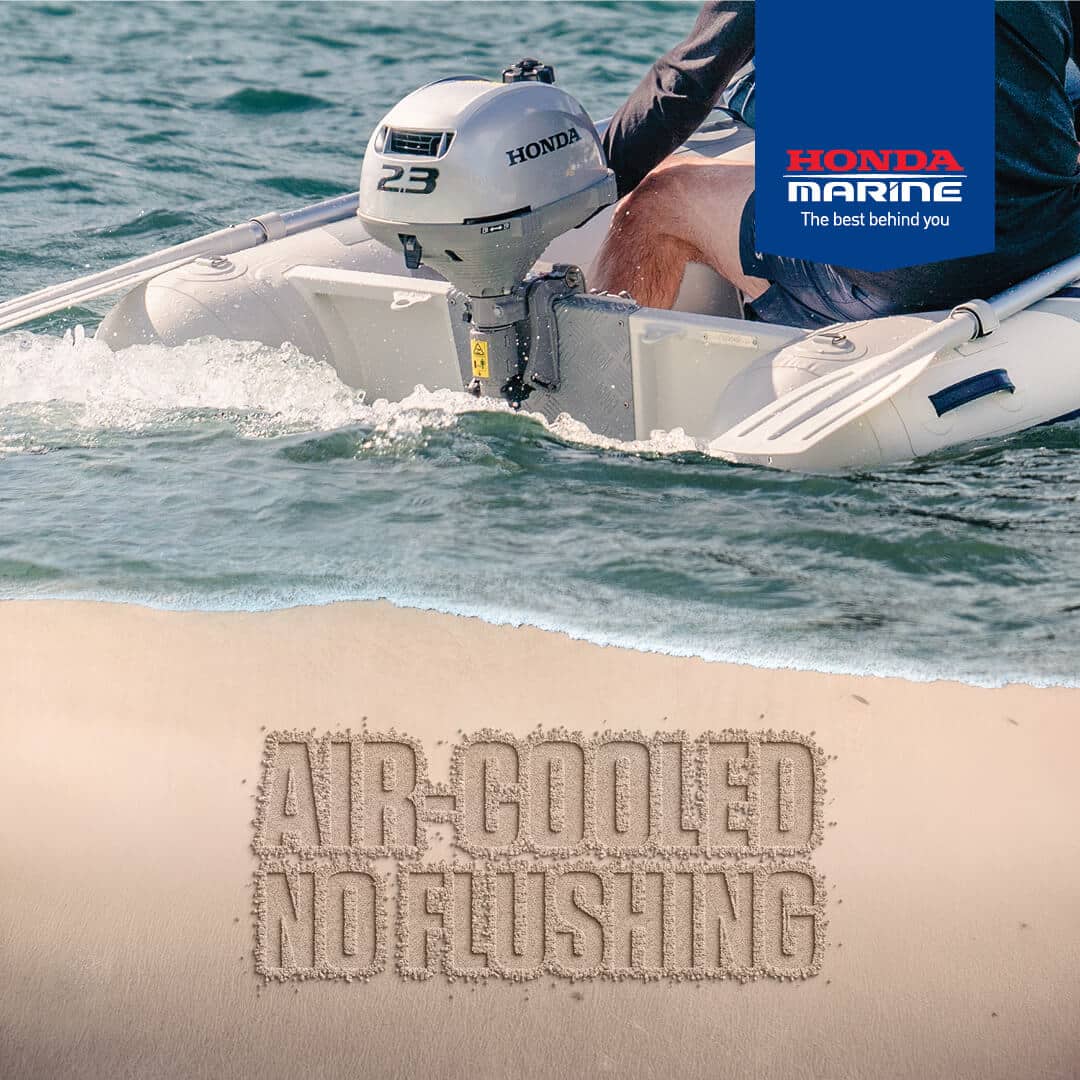 Honda Marine advertisement on a white inflatable boat with an outboard motor and a blue banner; slogan visible on the sand below.